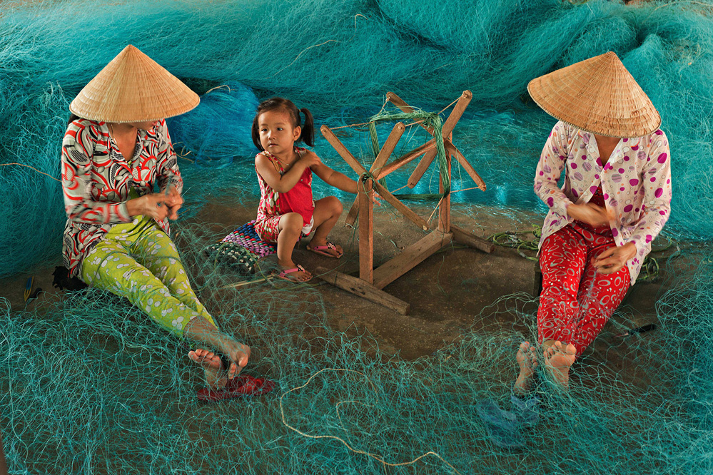 TRAVAL #2 THANH LAM Title Repairing Nets While Watching Child.jpg
